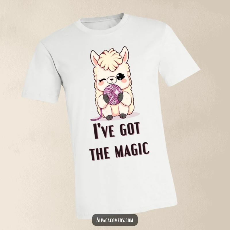 Funny t-shirt: An alpaca character gives a sly wink while holding a miniature, sparkling yarn ball, looking charmingly mischievous.